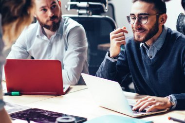 Ofis iç toplantı sırasında yeni strateji planlaması üzerinde birlikte çalışan genç gururlu CEO uzmanlarından oluşan yaratıcı ekip, beyin fırtınası brifingi ve işbirliği sırasında fikirleri tartışan bir grup çalışan