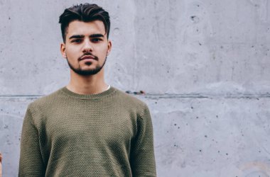 Yakışıklı erkek portresi kameraya bakarken kadın arkadaşı yüzünün önünde telefona bakarken, hipster adam kadına üzüldüğünü hissederken hücresel ihmal etme bağımlılığı vardır