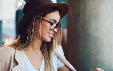 Kafedeki masada otururken boş ekranla gülümseyen ve dizüstü bilgisayarı karıştıran genç ve güzel bir serbest yazar.