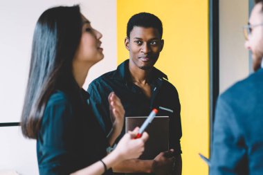 Asyalı kadın lider yapışkan notlar ile duvarın yanında duran erkek çalışanlara önemli bilgileri açıklamak, başarılı çalışanların çok kültürlü grup toplantıda fikir paylaşımı birlikte işbirliği