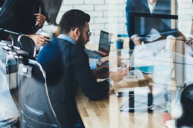 Çağdaş çatı katında karmaşık bir proje üzerinde çalışırken zarif giysiler içinde, belgelerdeki bilgileri analiz eden çok ırklı düşünceli çalışanların cam yüksek açısıyla.