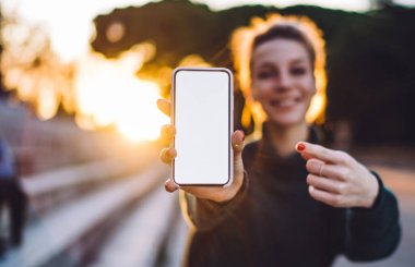 Metin dağıtım reklamları için metin alanı olan akıllı telefon görüntüsüne seçici odaklanma, bulanık arka planda bin yıllık kadın cep telefonuyla medya siteniz için boş ekran tutuyor