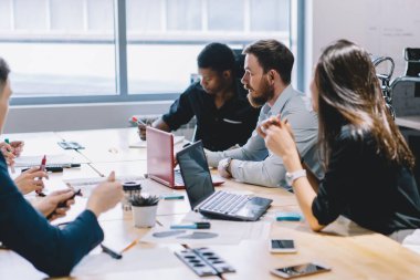 Gururlu ceo için şirket stratejisini tartışan konsantre erkek ve kadın çalışan genç ekip, iş arkadaşları arasında girişimciliği analiz eden çok kültürlü yöneticiler, iş ve meslek kavramı