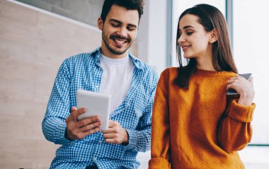 Pozitif hipster çocuklar dokunmatik yüzey üzerinde uygulama üzerinden komik komedi video online izlerken birliktelik, mutlu gülümseyen erkek ve kadın blogcular takipçileri ile sohbet zevk zaman harcama sırasında