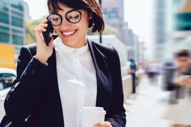 Resmi giyim başarılı gülümseyen kadın tüccar cep telefonu üzerinden iletişim kurmak için dolaşım internet bağlantısı kullanarak boş ve ofiste iyi maaş işe alma hakkında alınan haber heyecan