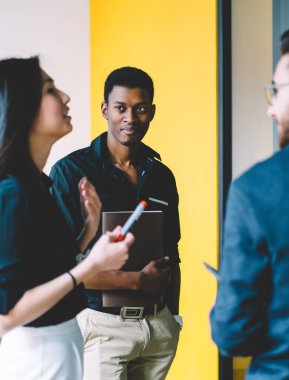 Asyalı kadın lider yapışkan notlar ile duvarın yanında duran erkek çalışanlara önemli bilgileri açıklamak, başarılı çalışanların çok kültürlü grup toplantıda fikir paylaşımı birlikte işbirliği