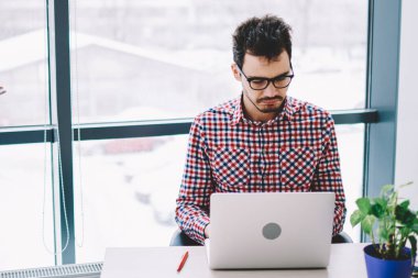 Hüsrana uğramış genç erkek iş arkadaşı dizüstü bilgisayar kullanıyor ve masada oturuyor. Bu sırada bayan düşünceli meslektaşı da akıllı telefondan mesaj atıyor ve ofiste pencerede dikiliyor.