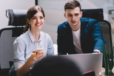 Sosyal ağlarda yayından gülen neşeli kadın, dizüstü bilgisayar uygulaması üzerinden kamu web sayfasında şirket haberleri okuma olumlu erkek ve kadın işçilerin bir grup kapalı işbirliği