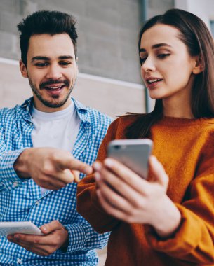 Bilgi paylaşımı için bluetooth bağlantısı akıllı telefon gadget ve dokunmatik yüzey kullanarak Bin yıllık kafkas hipster çocuklar, içerik web sitesinde haber okuma genç pozitif erkek ve kadın gençler