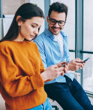 Modern akıllı telefonlar kullanarak Pozitif bin yıllık hipster çocuklar gerçek konuşma görmezden, genç erkek ve kadın çalışanlar teknolojileri ve internet ağ bağımlısı ve hücresel üzerinden sohbet