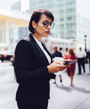 Gözlük okuma iş kadını yan görünümü metropolgitmek için kahve ile mola dururken akıllı telefonda bildirim aldı, e-posta kontrol etmek için 4g bağlantısı kullanarak emin yöneticisi