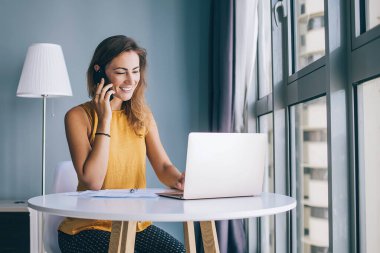 İnternet alışverişi sırasında internet mağazasında indirimler hakkında arkadaşlarıyla iletişim kuran olumlu kadın, cep telefonu cihazıyla konuşurken internet üzerinden bilet alan mutlu kadın.