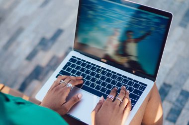 Ekranda bulanık renkli görüntü ile ön açık dizüstü bilgisayar oturan Afro-Amerikan kadın arka görünümü. Blog içeriğinde arama yaparken ağdaki kadın klavye isteğinin görünümünü yakından takip edin