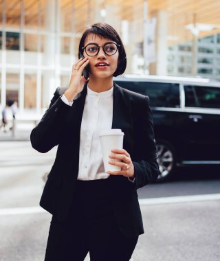 Genç kadın patron şehir merkezinde kahve molası sırasında hesap bakiyesi kontrol etmek için operatör hizmetine çağrı, eşi ile iletişim kurmak için akıllı telefon 4g bağlantı kullanarak zarif takım elbiseli kadın