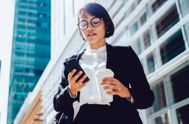 Görme düzeltme okuma için optik gözlük ciddi kadın patron görünümü aşağıda kafein içecek zevk için mola zaman şirket ofisine yol sırasında meslektaşım dan e-posta aldı