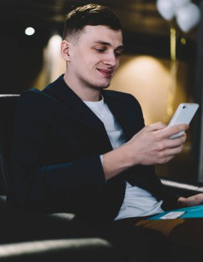 Akıllı telefon gadget kablosuz 4g internet kullanırken arkadaşlarınızla olumlu sohbet zevk Mutlu gülümseyen adam, başarılı erkek elinde cep telefonu tutarak ve iş arkadaşına metin cevap yazarak