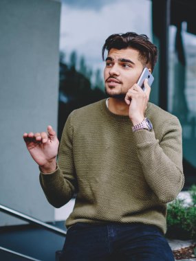 Yakışıklı adam açık havada oturan telefon görüşmesi sırasında bilgi açıklayan, hipster adam cep telefonu ile servis operatörü ile konuşma rezervasyon yapma danışmanlık detayları tartışıyor