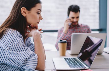 Kafkas kadın modern ofiste dizüstü bilgisayar kullanarak iş için online araştırma yapmaya konsantre, ciddi kadın girişimci internet tarama için netbook üzerinde uygulama üzerinden video izlerken