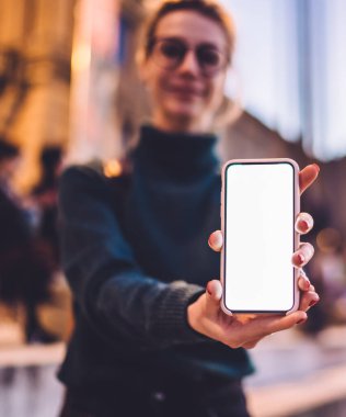 Reklam alanı veya içerik metni için fotokopi alanı olan boş akıllı telefon aygıtına seçici odaklanma, cep telefonu cihazının dokunmatik ekranında web sitesi gösteren milenyum kadını