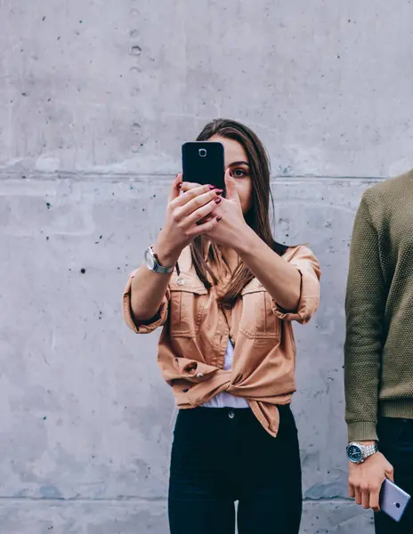 Yakışıklı bir erkek, kameraya bakarken, kız arkadaşı telefonuna bakıyor. Hipster bir adam, kadına kızıyor. Hücresel görmezden gelme alışkanlığı var.