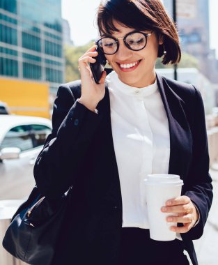 Resmi giyim başarılı gülümseyen kadın tüccar cep telefonu üzerinden iletişim kurmak için dolaşım internet bağlantısı kullanarak boş ve ofiste iyi maaş işe alma hakkında alınan haber heyecan