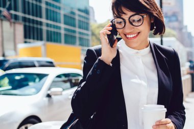 Resmi giyim başarılı gülümseyen kadın tüccar cep telefonu üzerinden iletişim kurmak için dolaşım internet bağlantısı kullanarak boş ve ofiste iyi maaş işe alma hakkında alınan haber heyecan