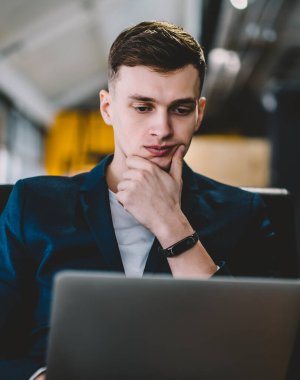 Konsantre erkek yazılım geliştirici modern netbook üzerinden iş ortağı ile online iyi internet bağlantısı kullanarak iletişim için dizüstü bilgisayar uygulaması güncelleme