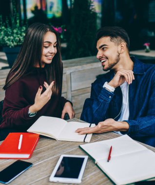 Neşeli kadın ve adam dizüstü bilgisayarlar ile kafe terasında birlikte oturma planlama için olumlu bir tartışma, gülümseyen hipsters not defteri bilgi hakkında iletişim birlikte araştırma keyfini