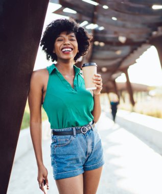 Yazın şehirde kameraya poz veren neşeli koyu tenli kadın portresi, kaygısız ve mutlu Afrikalı Amerikalı hippi kız. 