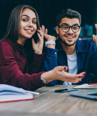 Kafe terasında dizüstü bilgisayar kullanarak web mağazasında satış kutlayan gözlük duygusal hipster adam Portresi ise onun kadın meslektaşı rezervasyon yapmak için servis operatörü ile konuşurken