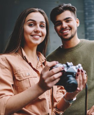Şehirde vintage kamera kullanarak hobi serbest zaman harcama neşeli erkek ve kadın arkadaşlar Portresi, hipster çift kamera ve gülümseme bakarak görüntü çekmek için ekipman ile birlikte dinlenme
