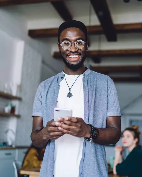 Веселий Афроамериканець Живе Друзями Вдома Пише Смс Мобільному Телефоні Посміхаючись — стокове фото