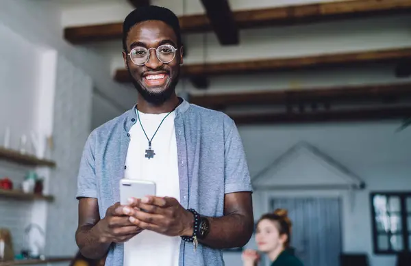 Веселий Афроамериканець Живе Друзями Вдома Пише Смс Мобільному Телефоні Посміхаючись — стокове фото