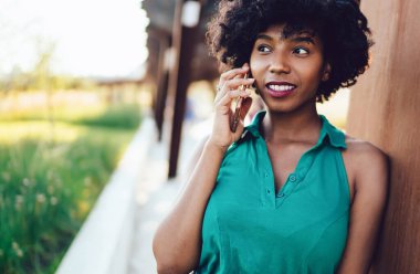 Güzel Afrikalı Amerikalı hippi kız modern hücresel cihaz ile arıyor, teknoloji ve iletişim kavramı. Genç, esmer bir kadın akıllı telefon aracılığıyla konuşuyor.