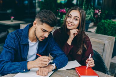 Genç beyaz erkek modern giyilebilir pc kontrol bildirim dokunmatik ekran bakarken kız arkadaşı kameraya bakarken, hipster adam kafe terasında zaman geçirmek için gps harcama için uygulama kullanıyor