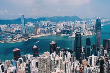 Hong Kong gökdelenlerinin insansız hava aracının panoramik manzarası Metropolitan körfezi ile gökdelenlerin ufuk çizgisi. Şehir merkezinde iş ve finans binaları olan modern beton şehir manzarası. Şehir altyapısı