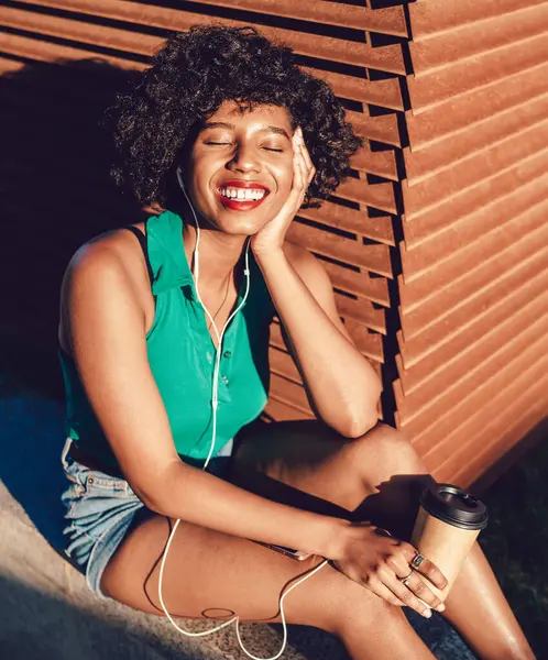 Cheerful African American female millennial feeling good from sunbath during summer day enjoying music with closed eyes, happy black woman listening motivation audio book via cellular app