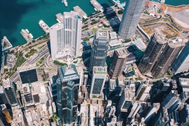 Hong Kong gökdelenlerinin insansız hava aracının panoramik manzarası Metropolitan körfezi ile gökdelenlerin ufuk çizgisi. Şehir merkezinde iş ve finans binaları olan modern beton şehir manzarası. Şehir altyapısı