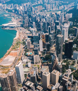 Hong Kong gökdelenlerinin insansız hava aracının panoramik manzarası Metropolitan körfezi ile gökdelenlerin ufuk çizgisi. Şehir merkezinde iş ve finans binaları olan modern beton şehir manzarası. Şehir altyapısı