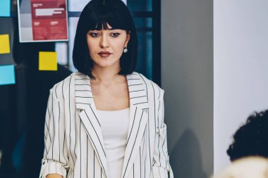 İşletme okulundaki çok ırklı öğrencilere atölye dersi veren ciddi bayan öğretmen, düşünceli kadın çalışanı, ofis masasında iş arkadaşlarıyla görüşlerini ve çözümlerini paylaşıyor.