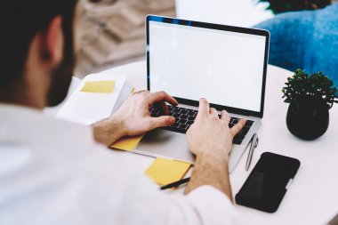 İnternet sitenizdeki reklam alanı, modern teknoloji konsepti ve iş mesafesi konsepti için ekran oluşturarak dizüstü bilgisayarda uzaktan çalışan yetenekli erkek yazılım geliştiricisinin arka görüntüsü