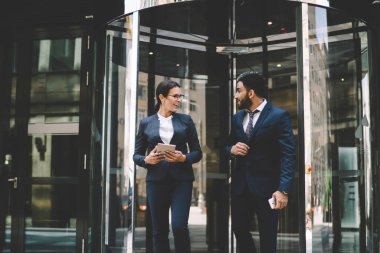 Pozitif erkek ve kadın iş arkadaşları birlikte vakit geçirmek için ofis binasından çıkıyorlar. Birlikte arkadaşlığın tadını çıkarıyorlar. Takım elbiseli başarılı ekonomistler iş birliğini tartışıyorlar.