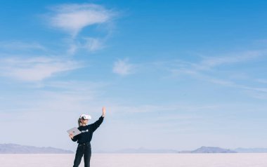 Kadın mimarın panorama tasarım yapım projesinde fütüristik manzarada sanal gerçeklik kulaklığı takarak tam boy görünümü.
