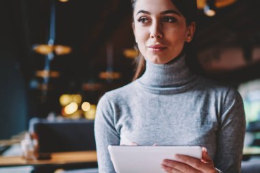 Pensive kız öğrenci düşünceli taşınabilir pc kapalı üzerinden ilginç film arama sırasında kenara bakarak, rüya kadın yeni elektronik gadget ve 4g internet kullanarak arkadaşları ile iletişim