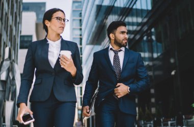 Ciddi erkek ve kadın iş arkadaşları finans bölgesinde tanıtım alanında dolanıyor ve ofis binası, girişimcilik ve iş hayatı konsepti için sözleşme detaylarını düşünüyorlar.