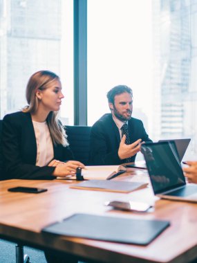 Konferans odasında yapılan beyin fırtınası sırasında şirketin finansal stratejisi konusunda işbirliği yapan bir grup şirket çalışanı masada otururken fikirleri tartışan başarılı ofis çalışanları.