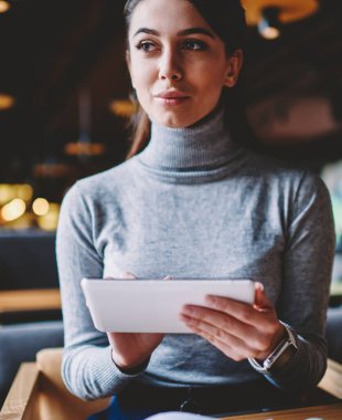 Pensive kız öğrenci düşünceli taşınabilir pc kapalı üzerinden ilginç film arama sırasında kenara bakarak, rüya kadın yeni elektronik gadget ve 4g internet kullanarak arkadaşları ile iletişim