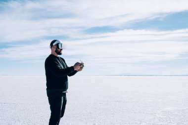 Genç gezgin, görsel alan denetimi için kuadkopteri uzaktan kumandayla ve sanal gerçeklik kulaklığıyla kontrol ediyor. Yeni nesil turistler için modern ve yenilikçi bir teknoloji. Benzetim ortamı