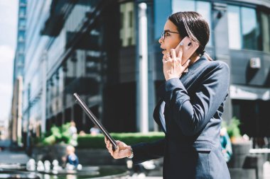 Erişkin beyaz kadın uzman, uluslararası görüşme sırasında ortakla birlikte cep telefonunda gezinme bağlantısını kullanarak dosyada sözleşmenin detaylarını tartışıyor. Ciddi kadın girişimcilikten bahsediyor.