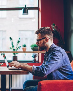 Akıllı telefon uygulaması ve elektronik kulaklıkla en sevdiği müzik listesini dinleyen güzel bayan melodinin yan görüntüsü ve dizüstü bilgisayarla internet iletişimini tercih eden erkek arkadaşına bakmak